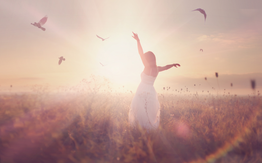 Woman standing in a field in sunlight