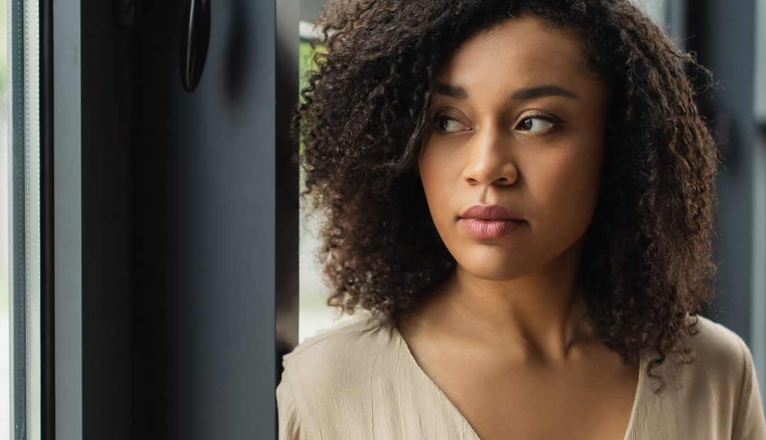 Young African American woman looking out the window