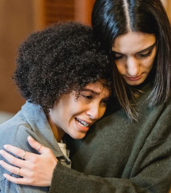 White woman comforting black woman