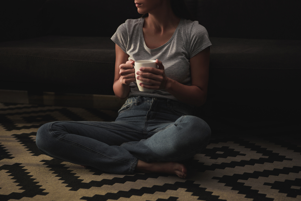 Woman sitting on floor with coffee