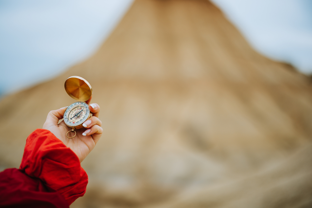 woman holding compass in a desert